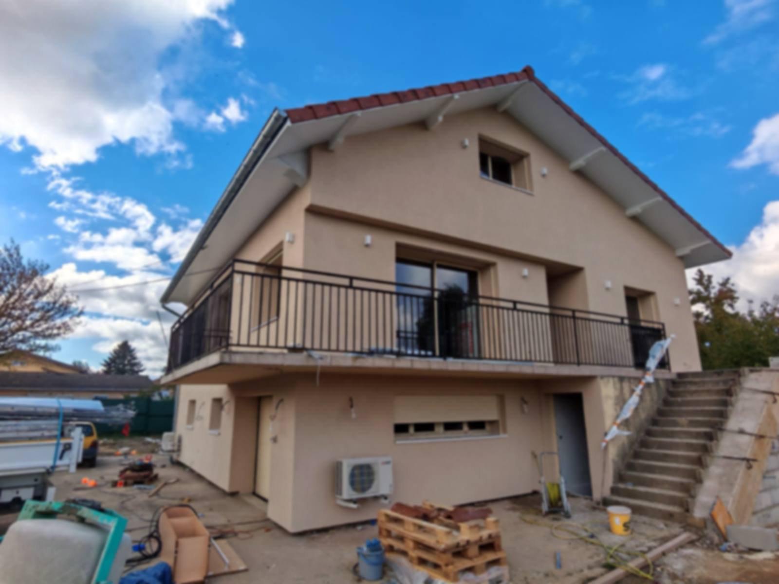Maison isolée par l'extérieur par Rev'Iso, enduit beige et pompe à chaleur Mitsubishi Electric