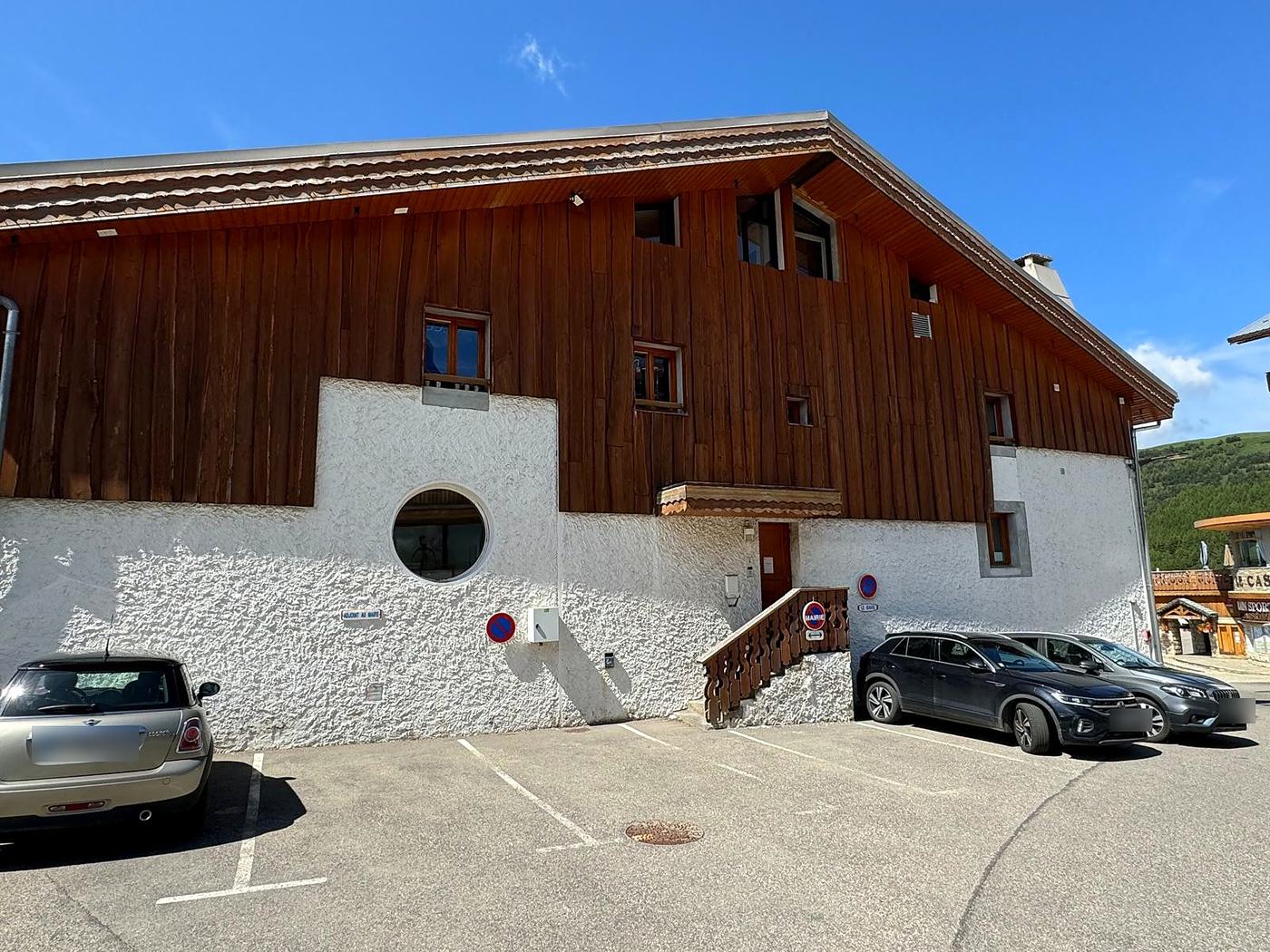 Façade latérale de la mairie avant travaux, crépi blanc et bardage bois sombre