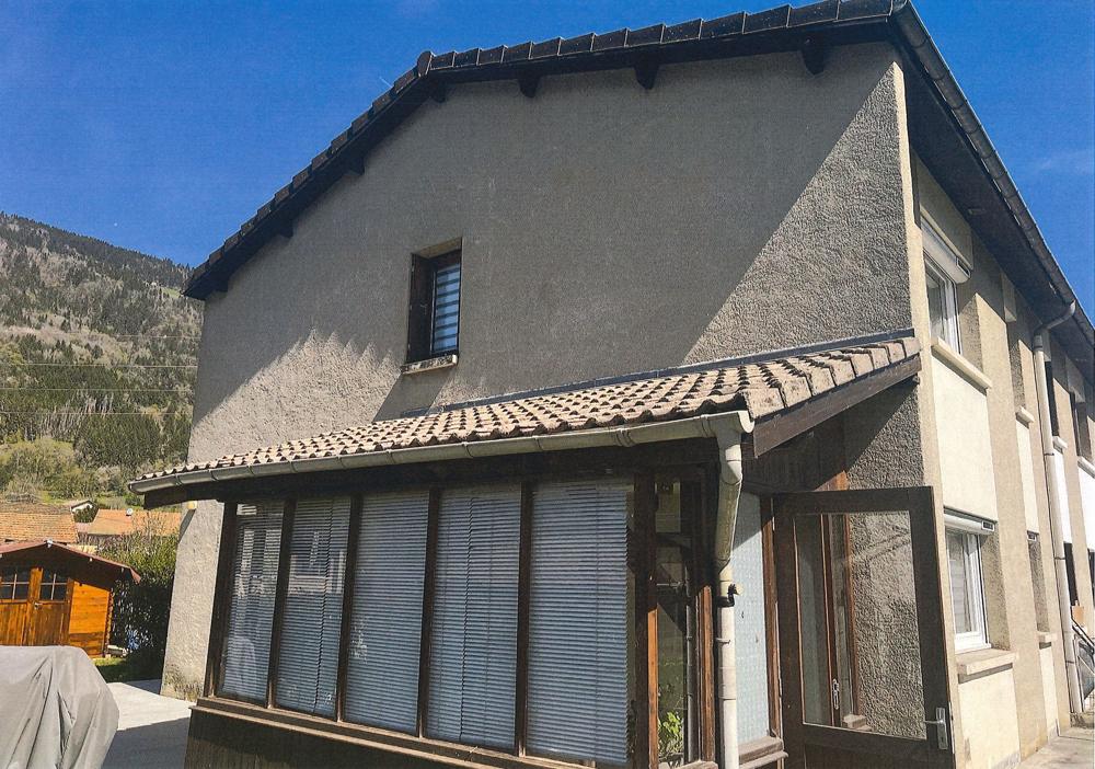 Maison avec véranda avant rénovation : façade grise, murs non isolés